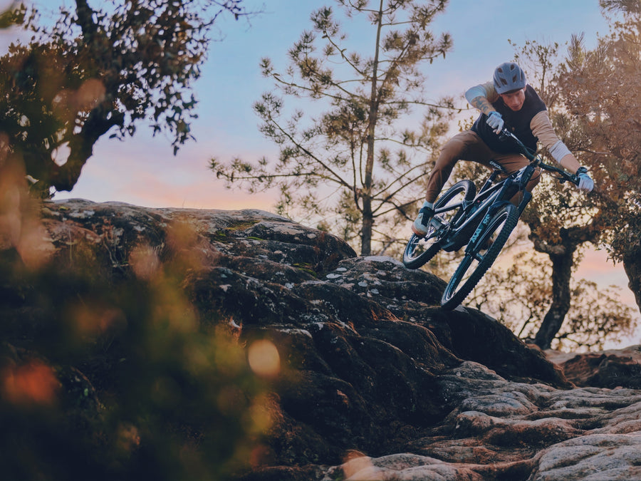 Jasper Jauch dropping into a rock slab on a bike running Sidekick hubs.