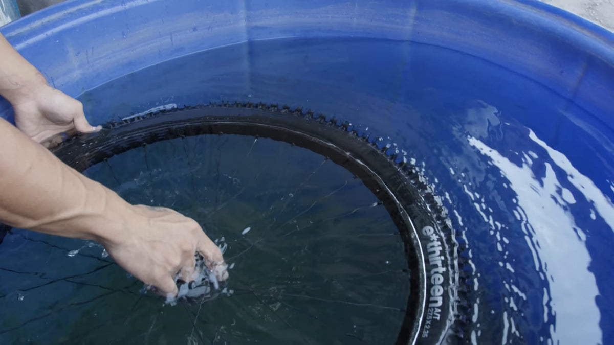 An e*thirteen tire held under water in the leak test tank. Still from Freehub Magazine's film Made With Love.